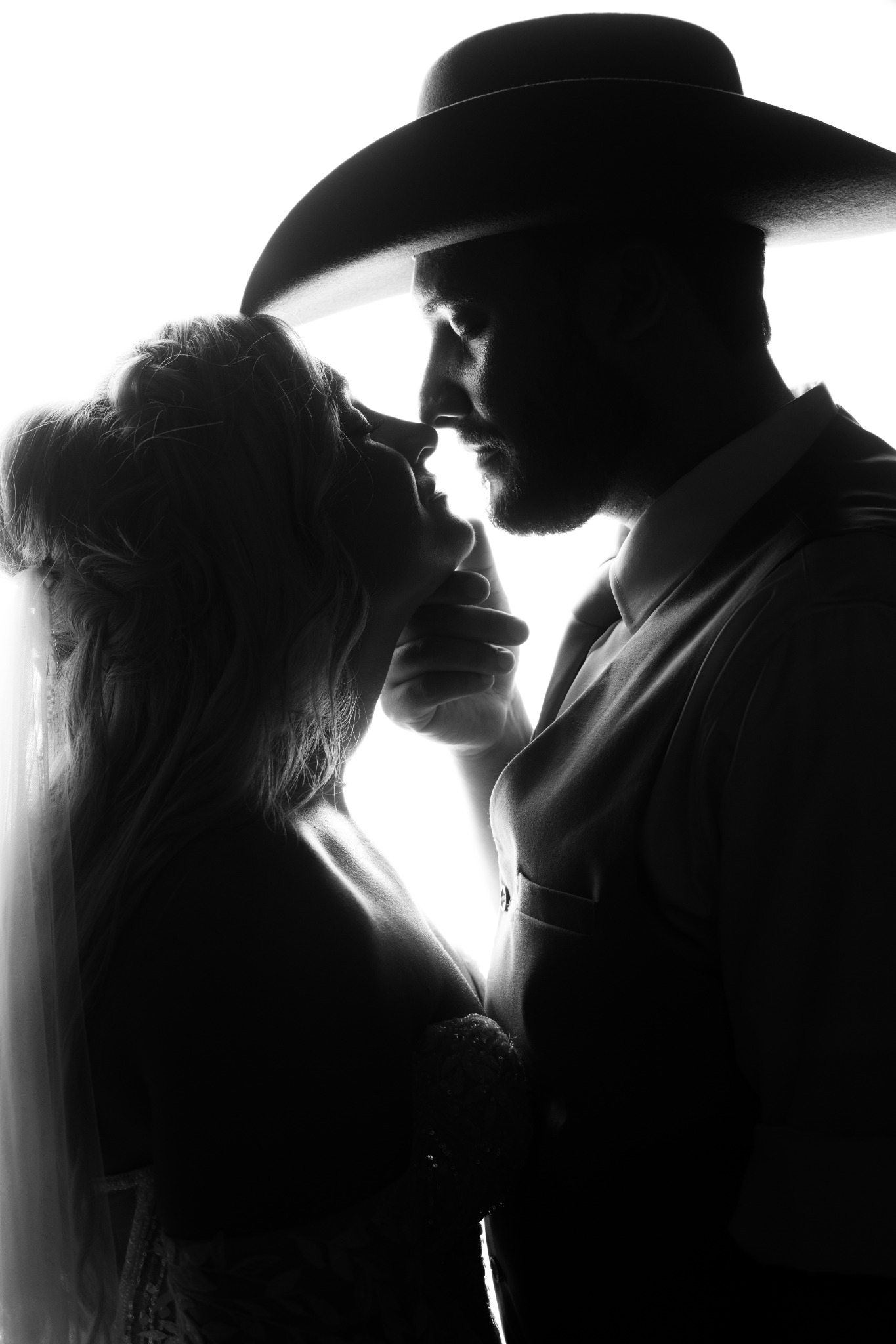 Newlyweds sharing a quiet portrait beneath the groom’s cowboy hat at Wildhorse at Parker Farms