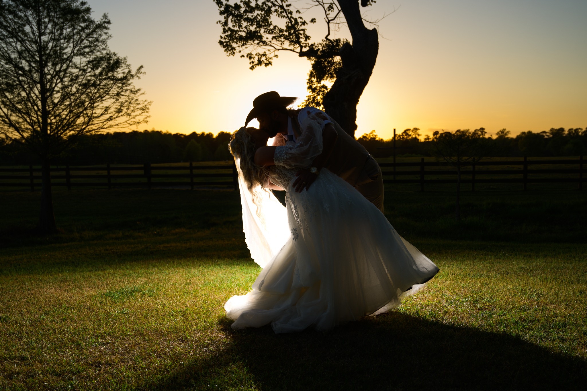 Newlyweds kissing in an open field at sunset at Wildhorse at Parker Farms