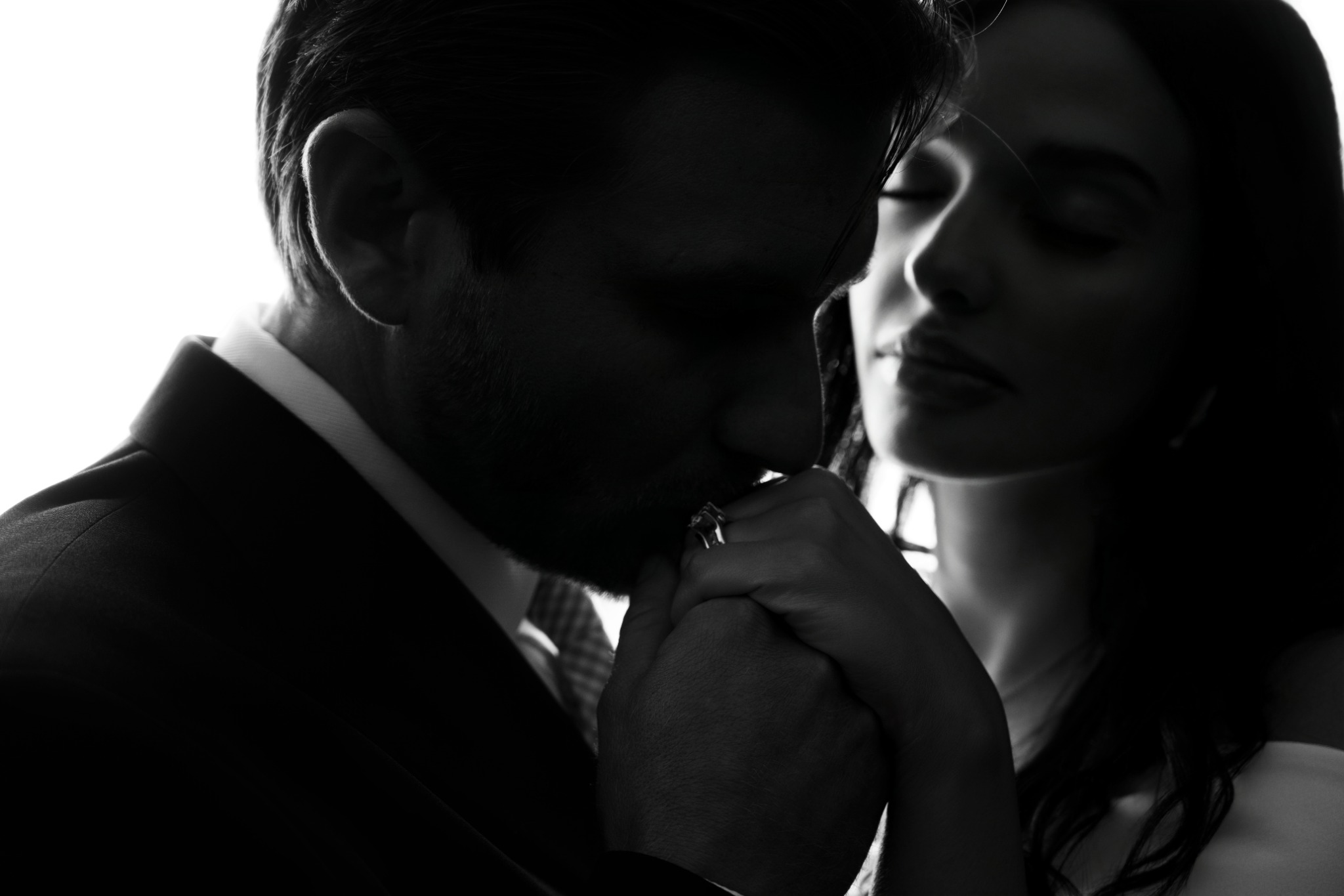 Black-and-white close portrait of newlyweds in window light